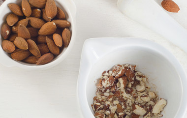 Almond nuts in white mortar.