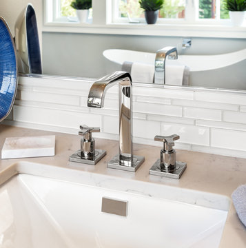 Bathroom detail in new luxury home: sink and faucet with view of
