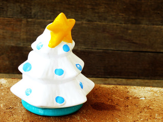christmas tree with yellow star ceramic on wooden background still life