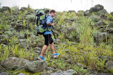 Young caucasian man go trekking on a roccky hill