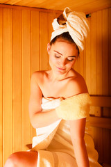 woman relaxing in wooden sauna room