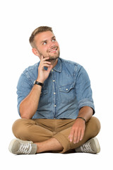 Obraz premium Young man sitting on the floor, imagining