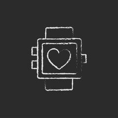 Smartwatch with heart sign icon drawn in chalk.