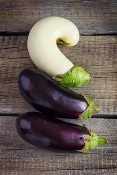 Three eggplants on an old wooden table