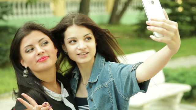 Two dark-haired women make Selfe.