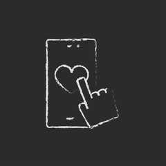 Smartphone with heart sign icon drawn in chalk.