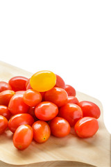 pile of cherry tomatoes on a wooden cutting board