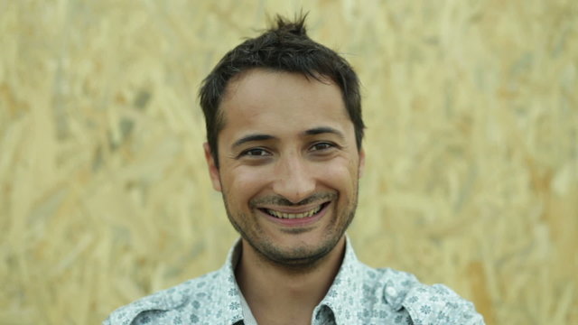 unshaven man smiling and hamming