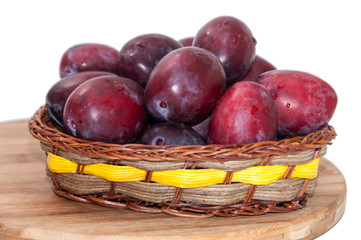 Fresh plums in the wooden basket