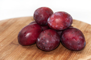 Fresh cleaned plums on the kitchen wooden board