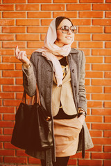 girl posing on a background of red brick wall