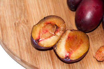 Opened plums on the wooden board