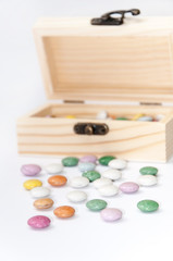 Fototapeta na wymiar Wooden chest gift box with colorful round chocolates