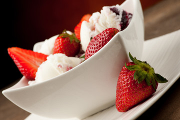 Strawberry icecream in a white bowl  with strawberries