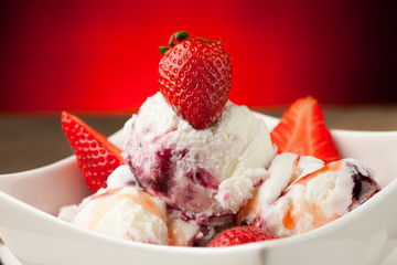 Strawberry icecream in a white bowl  with strawberries