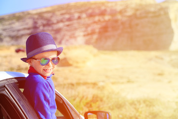 Fototapeta premium happy little boy travel by car in mountains