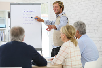 Business instructor leading meeting with senior training group