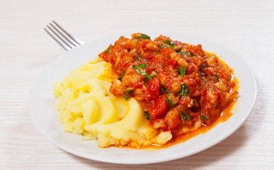 pieces of fish in tomato sauce with mashed potatoes