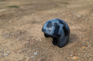Obraz premium Scratched helmet on ground. Selective focus.