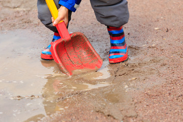 child playing in water puddle, kids outdoors