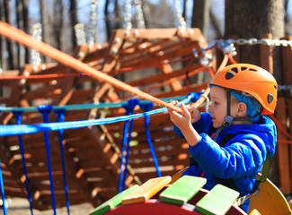 little boy climbing in adventure activity park