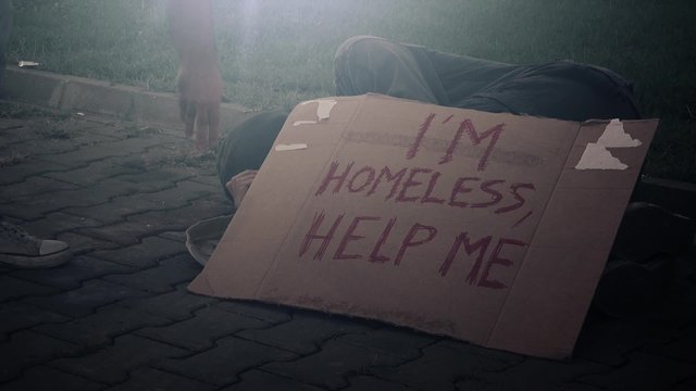 People giving change money to homeless person sleeping and begging on the street, 1080p hd footage