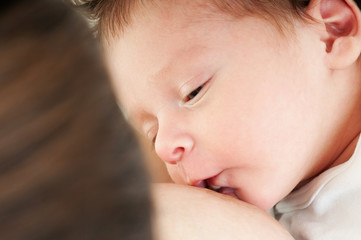 Close-up portrait. Young mother breastfeeds her baby. Breast-fee