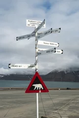 Gordijnen Road sign with polar bear and distances to the cities © dinozzaver