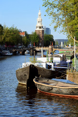 Gracht mit Hausboot in Amsterdam mit Montelbaanstoren als Turm