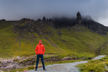 Obraz premium Man standing, looking at the Old Man of Storr, Scotland