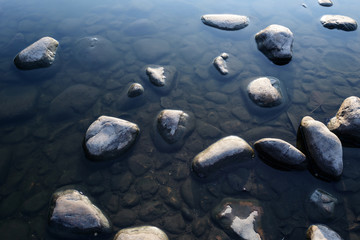 a clear and still brook and stones scattered all over