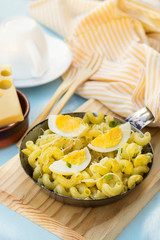 Fried pasta with boiled eggs, cheese and chives