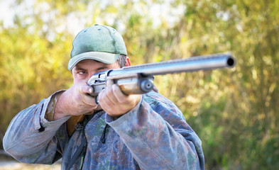 Hunter taking aim at the target. Hunter with a gun.