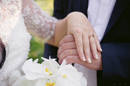 Wedding rings on the hands of newly-weds