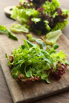 Plate of fresh mixed green salad on wooden table close up