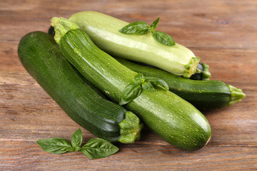 Fresh zucchini with squash and basil on wooden table close up