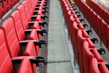 Red seats for fans on the tribune's sector of a modern football stadium