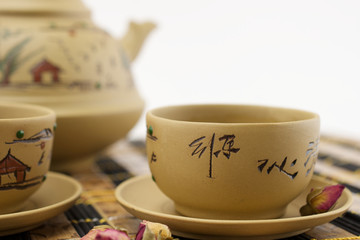 Chinese traditional clay teapot and cups of tea on bamboo mat