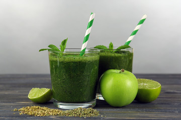 Green healthy juice with fruits and mint on gray background
