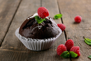 Delicious chocolate cupcake with berries on wooden table close up
