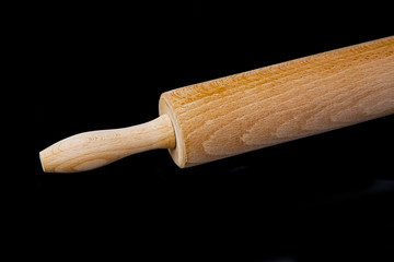 close up of rolling pin on black background