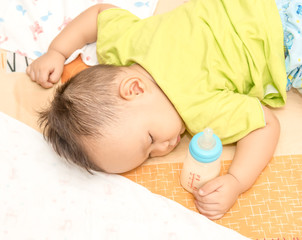 Obraz na płótnie Canvas baby hand holding milk bottle while sleeping