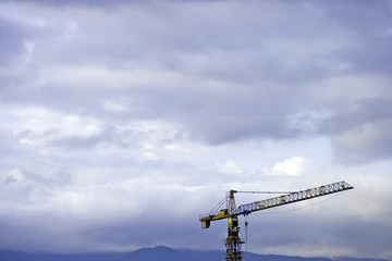 Industrial crane and stormy sky