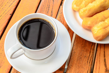 Coffee cup with patongko on wood table, coffee break