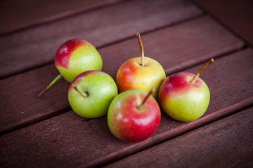Small pears variation in a group on wooden table, natural light