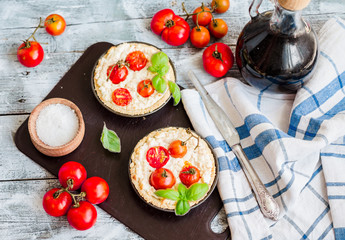 quiche with goat cheese, cherry tomatoes and basil on blue woode