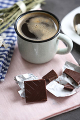 Cup of flavored coffee with chocolate on table with napkin, closeup
