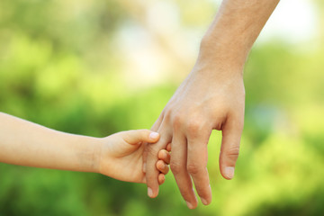 Father and daughter hands outdoors