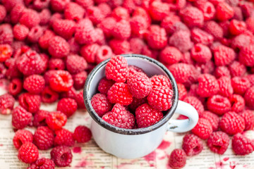 fresh red raspberries in a metal mug and placer