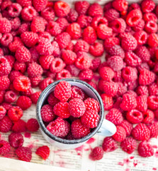 fresh red raspberries in a metal mug and placer